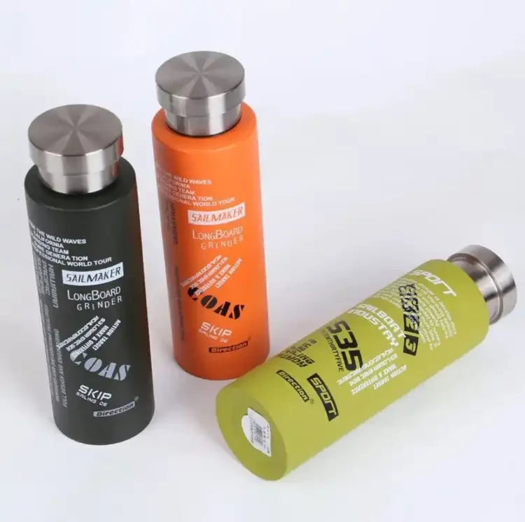 Three cylindrical bottles with metallic caps on a white background