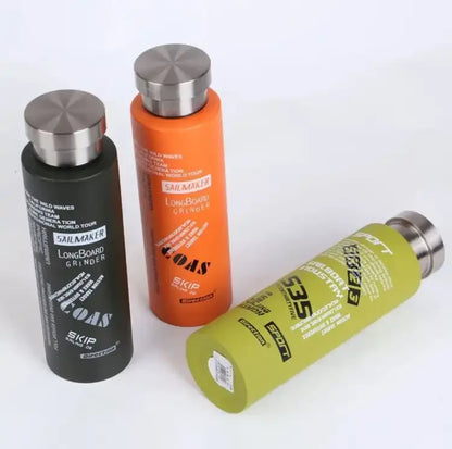 Three cylindrical bottles with metallic caps on a white background