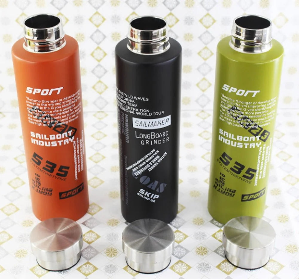 Three gradient bottles in orange, black, and green with metallic caps on a patterned background.