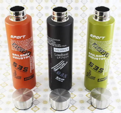 Three gradient bottles in orange, black, and green with metallic caps on a patterned background.